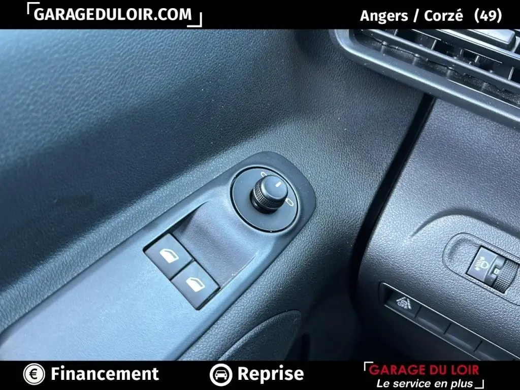 Détail des commandes de réglage des rétroviseurs et des vitres côté gauche dans l’habitacle du Peugeot Rifter bleu 2024.