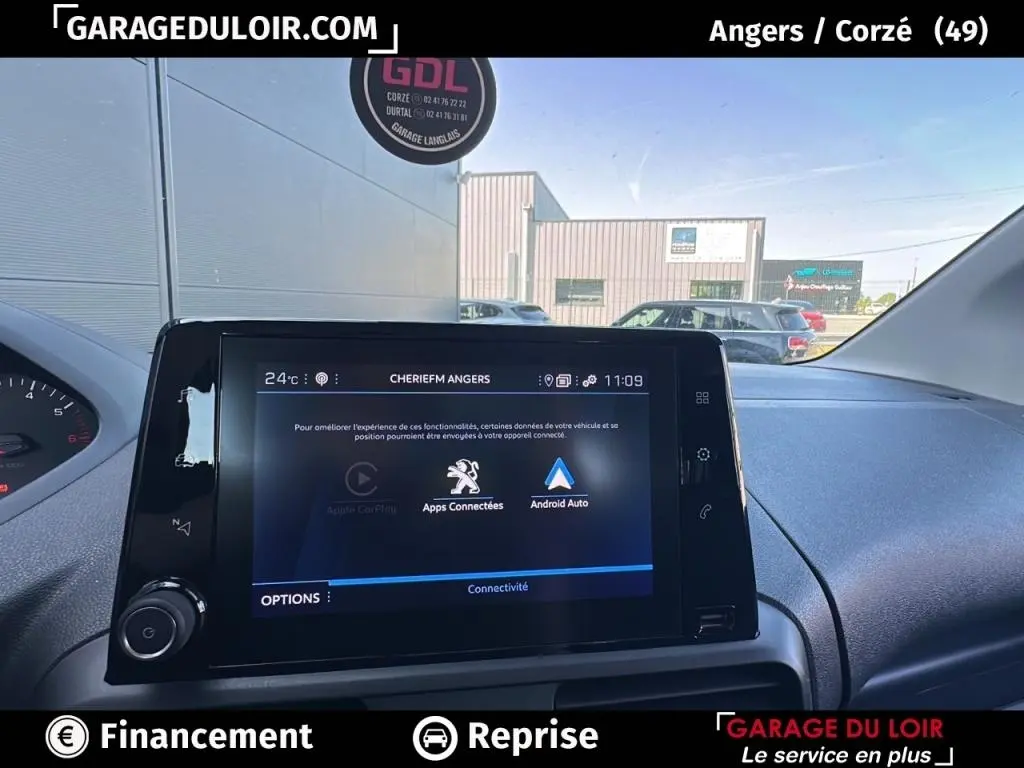 Vue intérieure centrée sur l’écran tactile multimédia du Peugeot Rifter bleu 2024, affichant les options de connectivité.