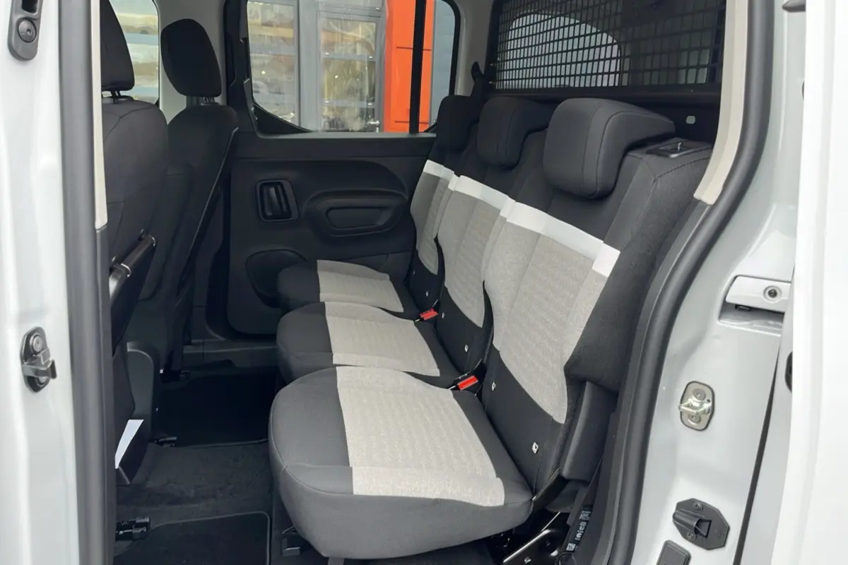 Vue latérale des sièges arrière tissu gris clair et noir du Citroën Berlingo Kaolin White avec grille de séparation amovible.