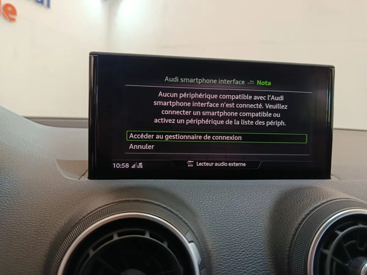 Écran tactile central affichant l'interface smartphone Audi dans l'habitacle gris foncé de l'Audi Q2 35 TFSI Business Line.