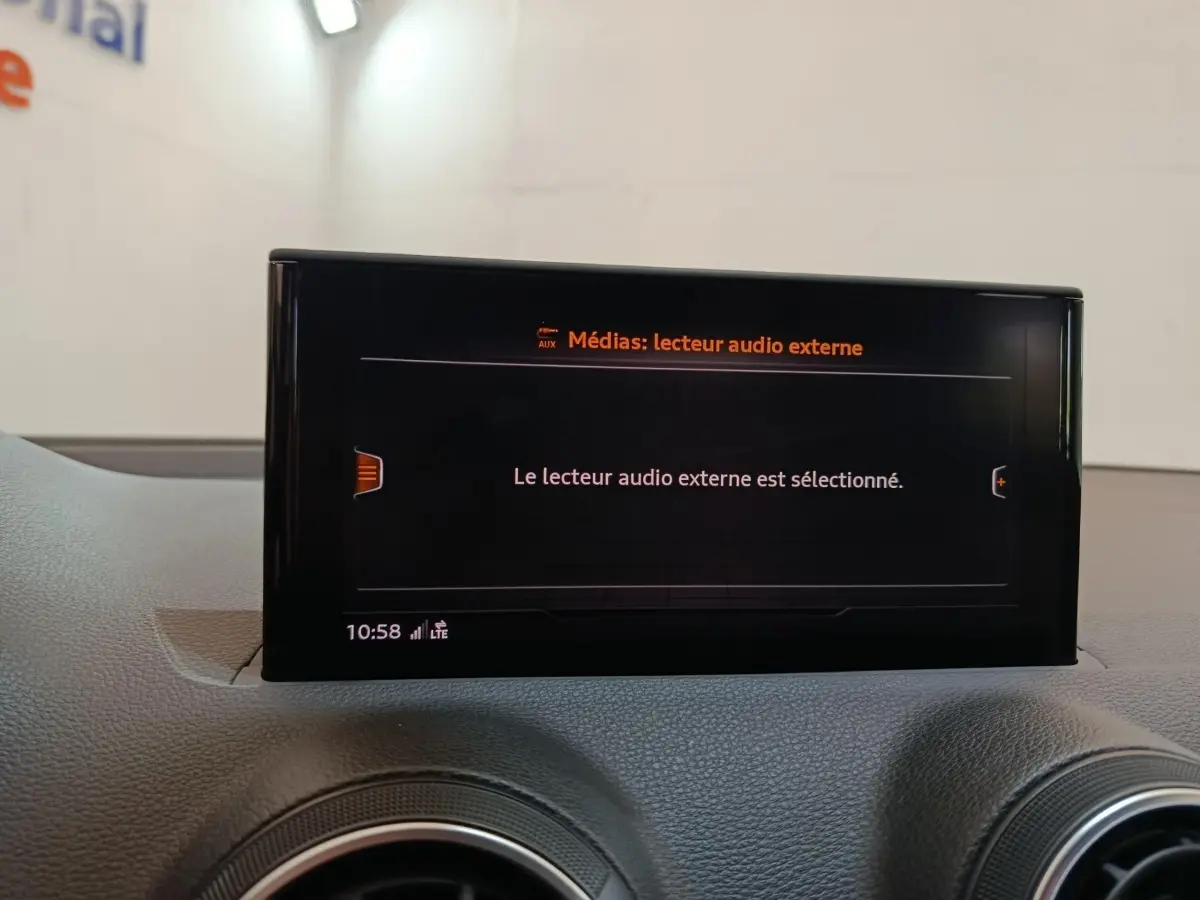 Écran tactile central affichant la sélection du lecteur audio externe dans l'Audi Q2, vue intérieure frontale.