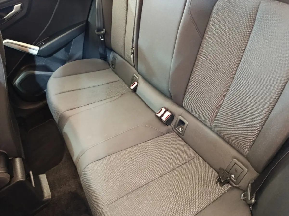 Vue intérieure côté droit de la banquette arrière grise foncée de l'Audi Q2 35 TFSI 2022 avec ceintures et fixations Isofix visibles.