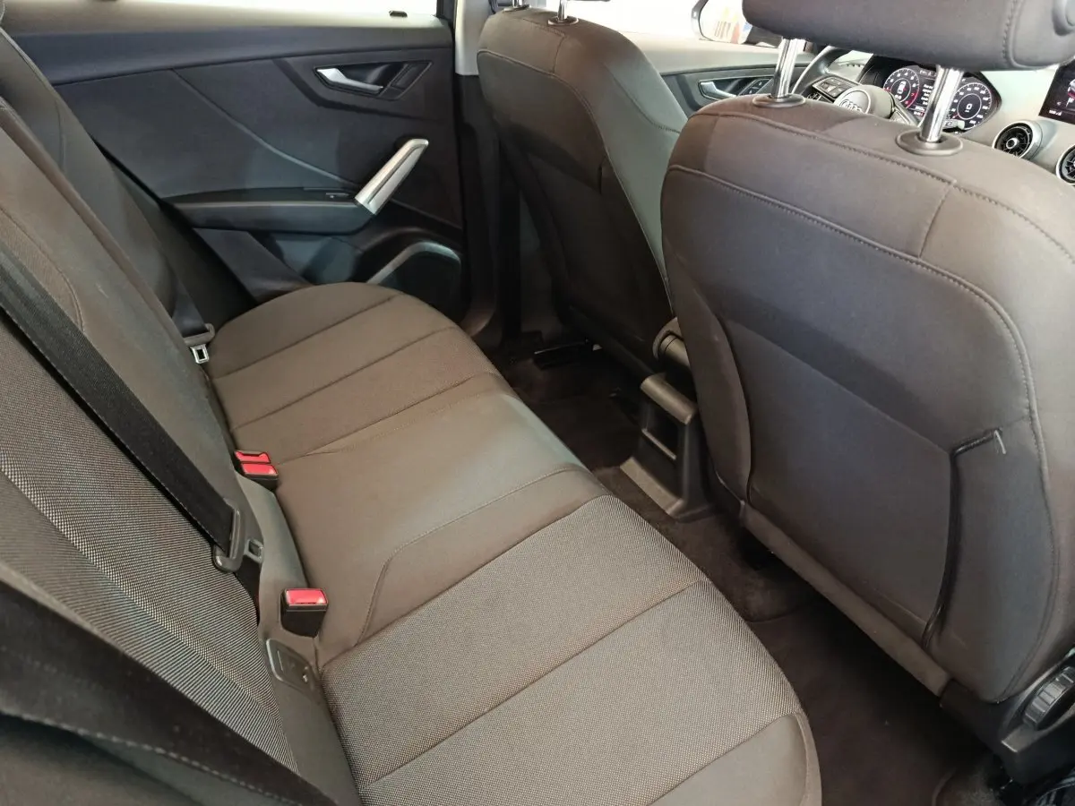 Vue intérieure arrière côté droit de l'Audi Q2 35 TFSI 150 S Tronic Business Line 2022 avec sièges tissu gris foncé.