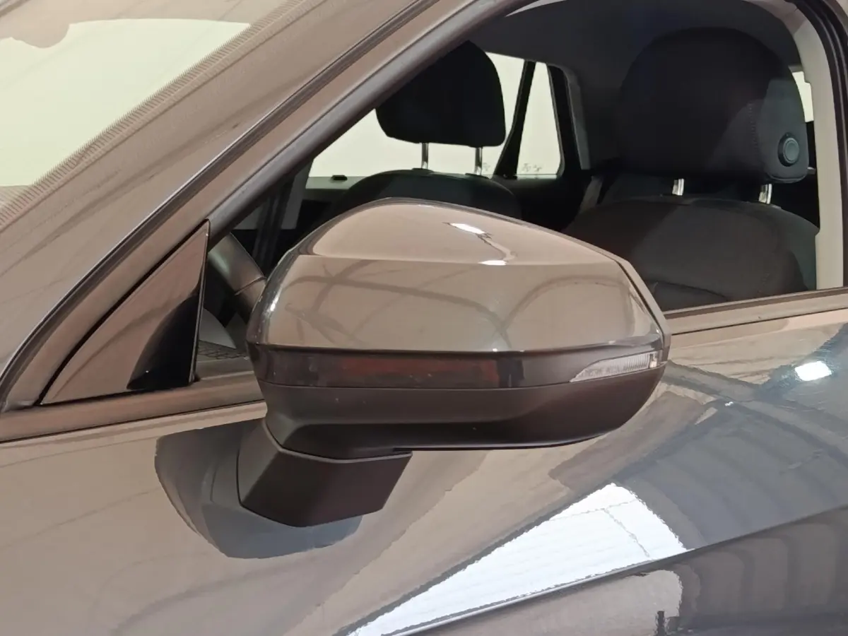 Rétroviseur droit gris foncé d’un Audi Q2 35 TFSI 150 S Tronic Business Line, intérieur noir visible.