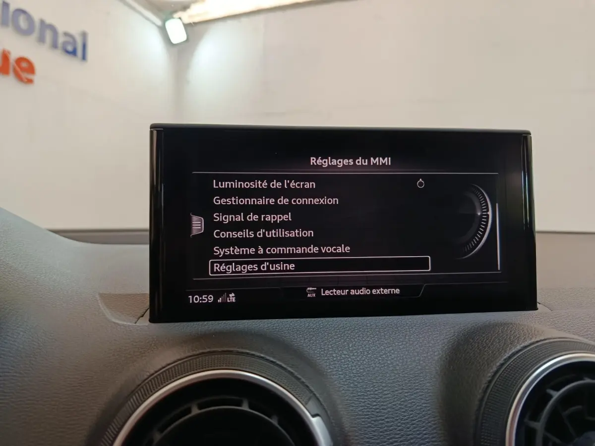 Écran central tactile affichant les réglages du MMI sur le tableau de bord gris d’un Audi Q2 35 TFSI 2022.