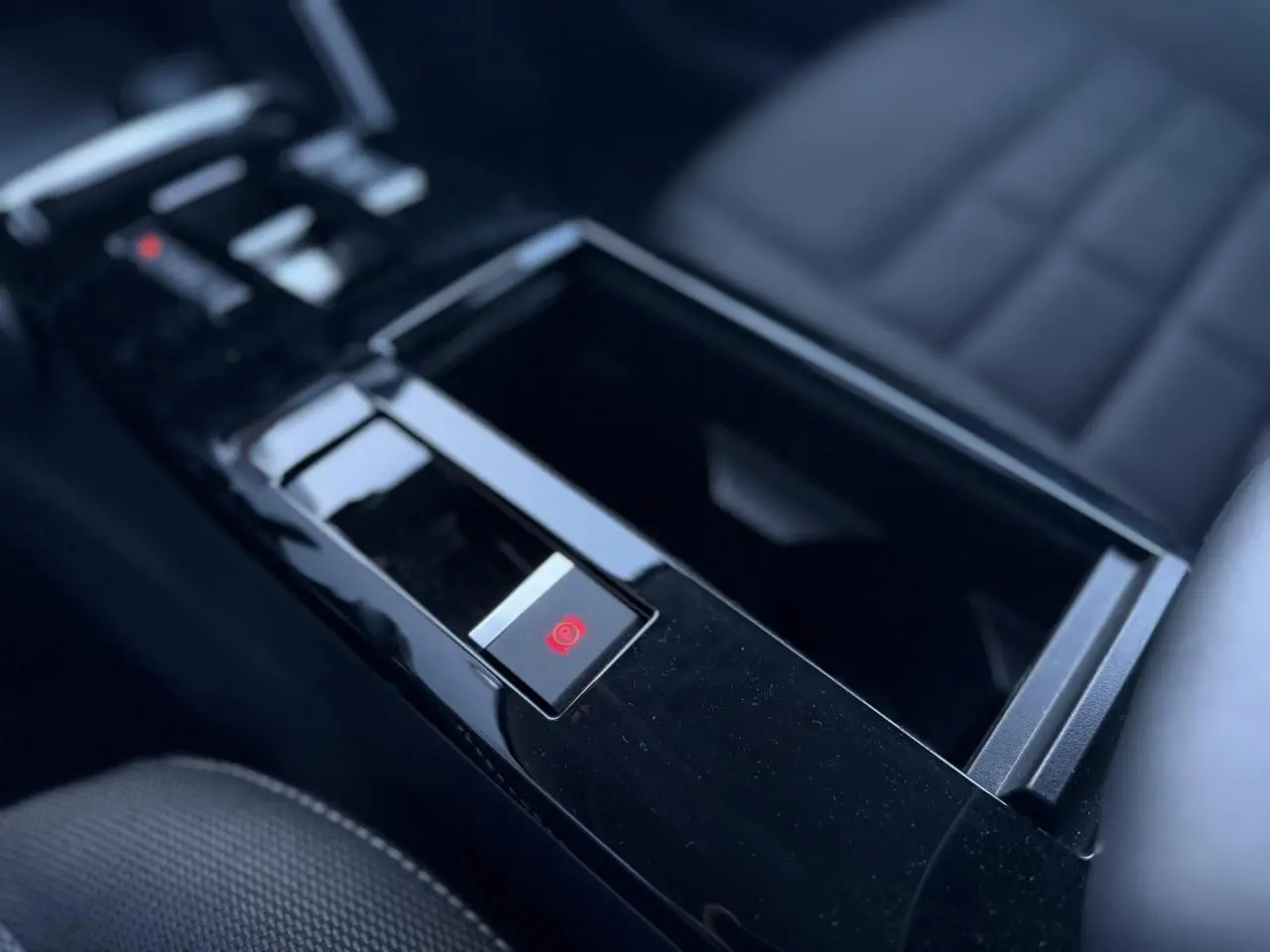 Gros plan sur la console centrale noire brillante avec frein de stationnement électrique de la Citroën C4 Hybrid 2025.