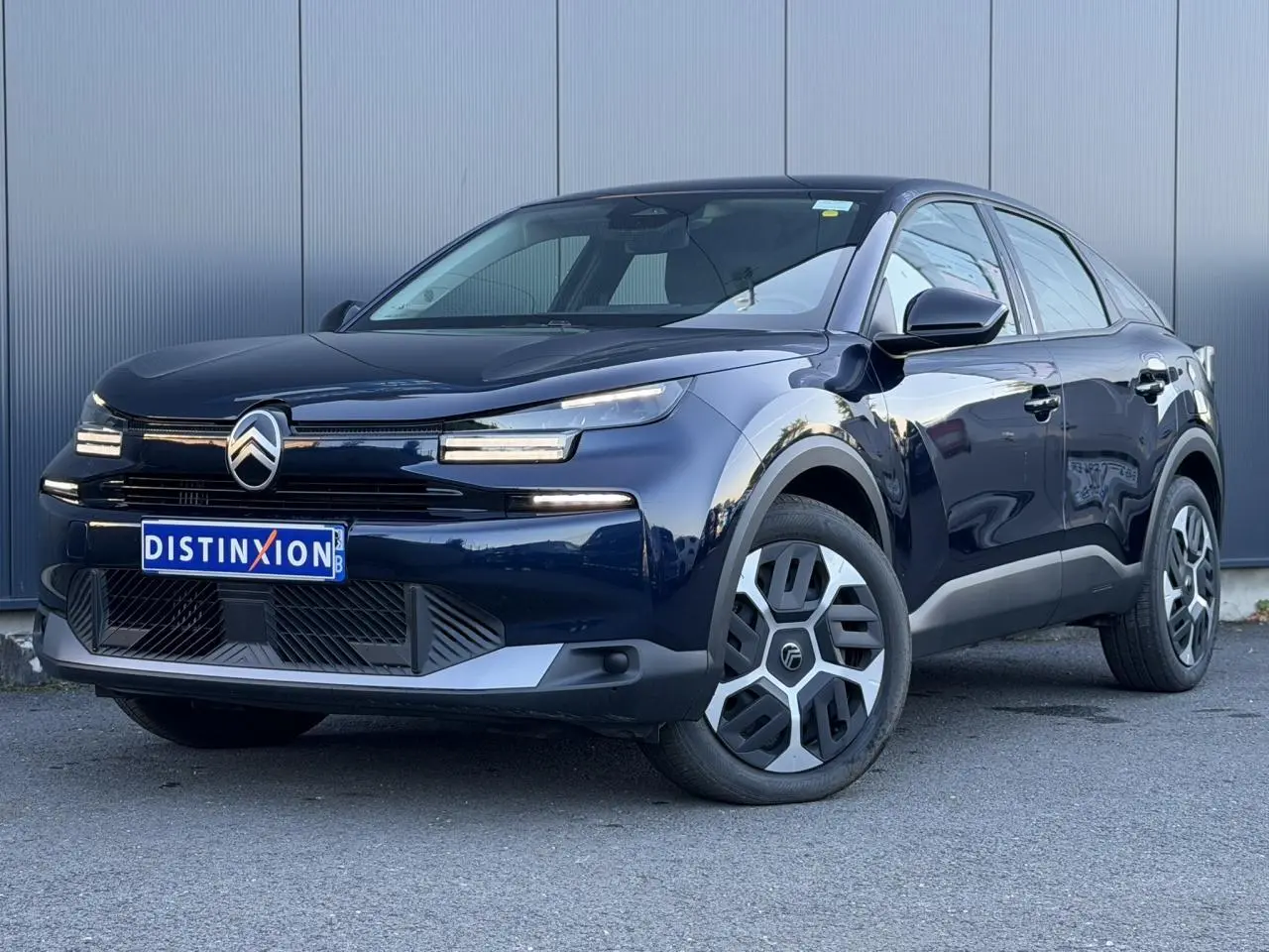 Citroën C4 Hybrid 145 bleu Eclipse en 3/4 avant droit, avec signature lumineuse LED et jantes spécifiques.