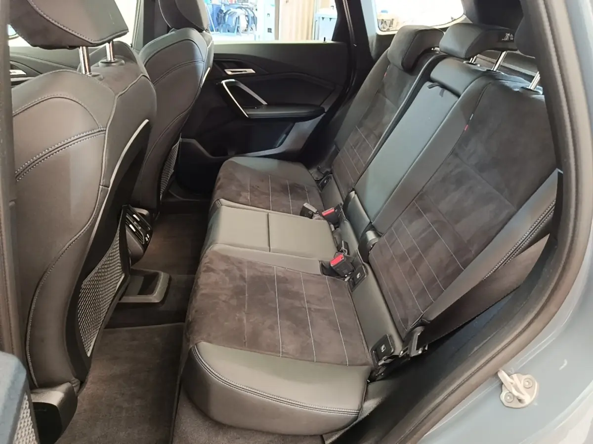Vue intérieure côté droit des sièges arrière en cuir et alcantara gris foncé du BMW X1 xDrive25e M Sport 2023.