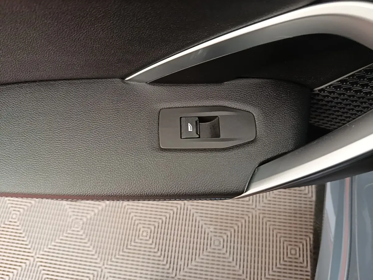Détail de la poignée intérieure côté conducteur du BMW X1 xDrive25e M Sport gris foncé avec bouton de verrouillage.
