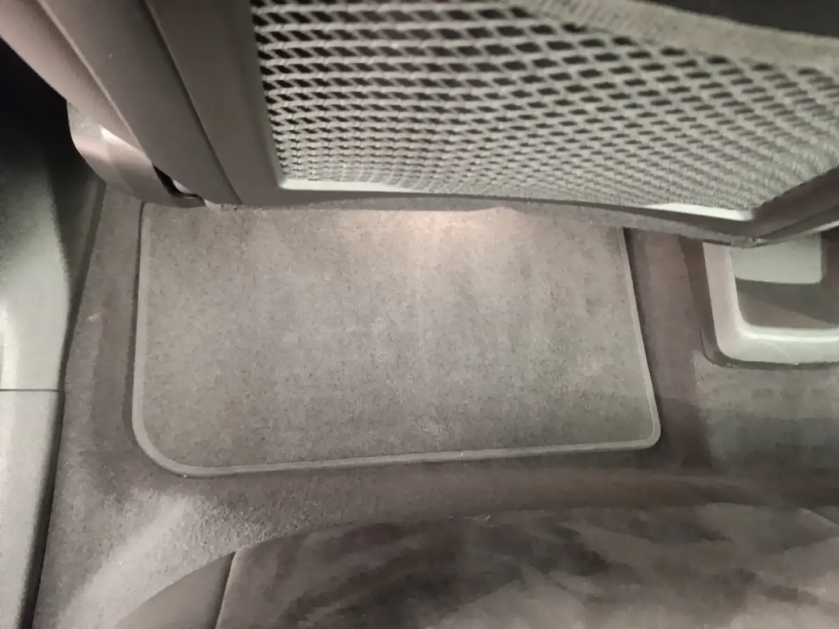 Vue intérieure du plancher avant droit du BMW X1 xDrive25e M Sport gris foncé, avec tapis de sol gris clair.
