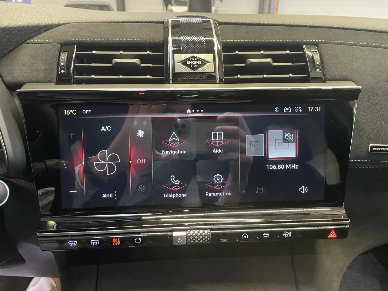Vue rapprochée de l’écran tactile central noir brillant du DS7 Crossback gris titanium avec commandes climatisation et bouton start/stop.