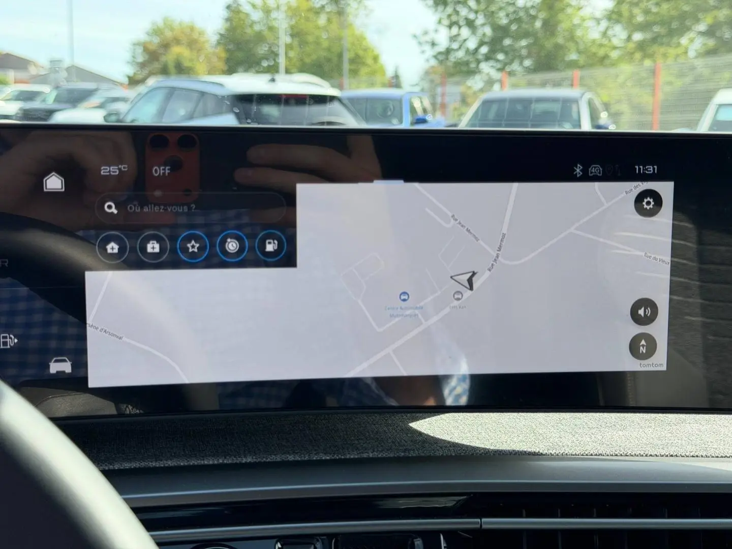 Écran tactile intérieur du Peugeot 3008 Hybrid 2026 affichant la navigation, avec reflet du volant et extérieur flou.