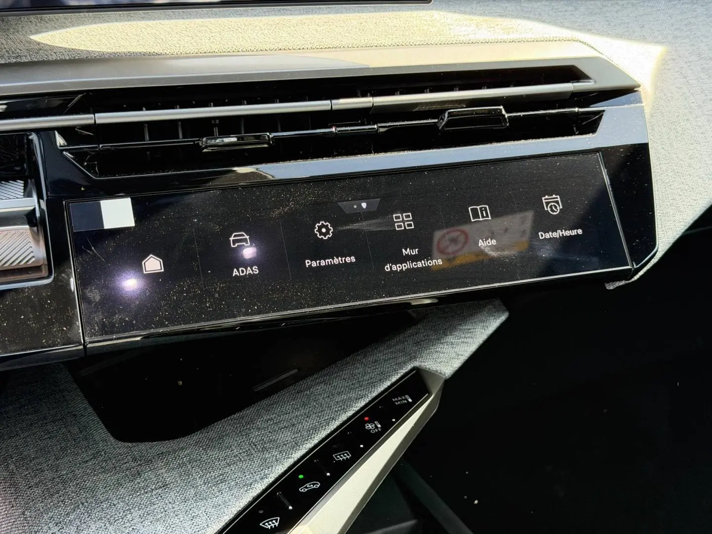 Vue rapprochée de la console centrale du Peugeot 3008 noir, écran tactile et commandes climatisation visibles.