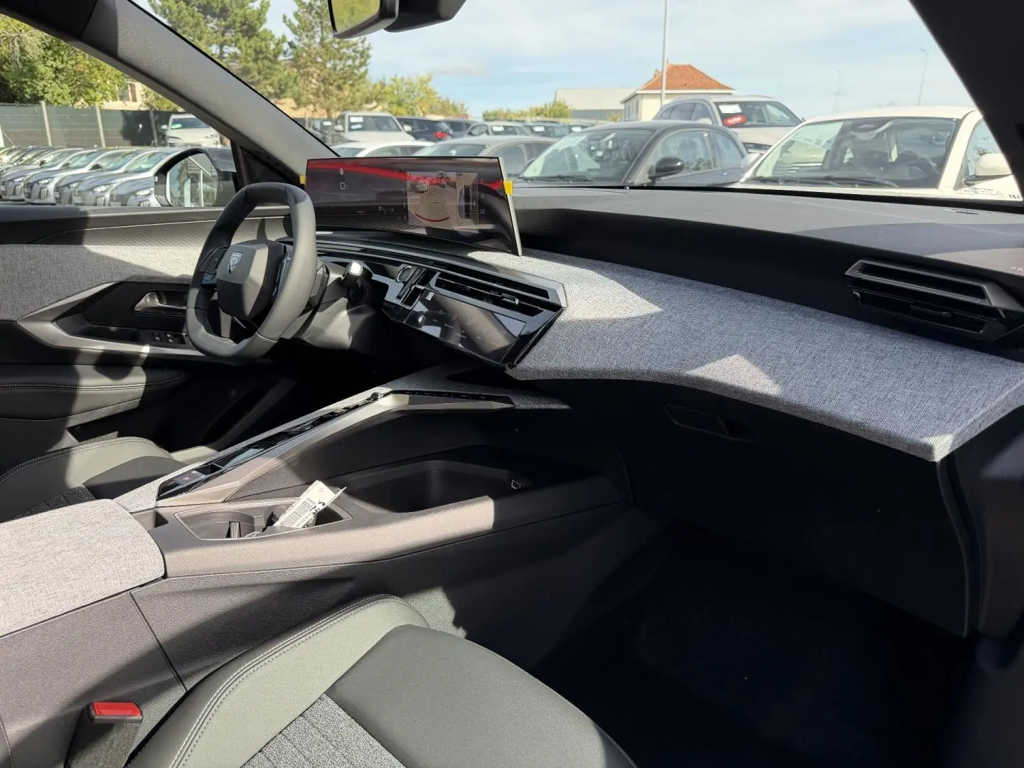 Vue intérieure côté passager du Peugeot 3008 2026, tableau de bord gris clair avec écran tactile flottant.