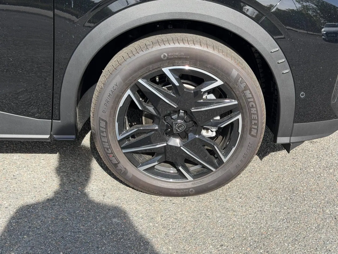 Gros plan sur la roue avant gauche noire avec jante alu au design moderne du Peugeot 3008 noir Perla Nera.