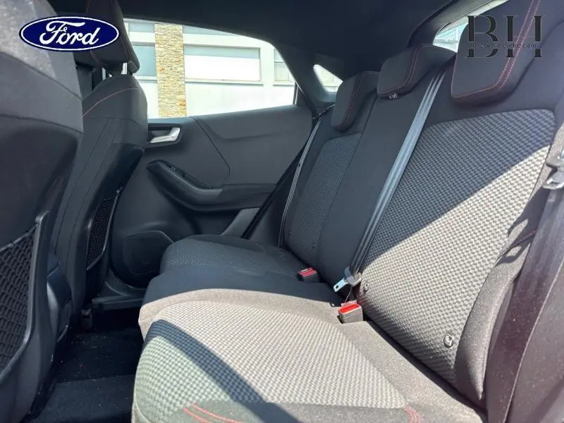 Vue latérale droite de l'arrière intérieur du Ford Puma 2022 avec sièges sport noirs et surpiqûres rouges.