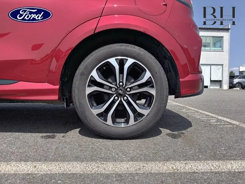 Gros plan sur la roue arrière droite du Ford Puma rouge métallisé avec jante alu au design sportif.