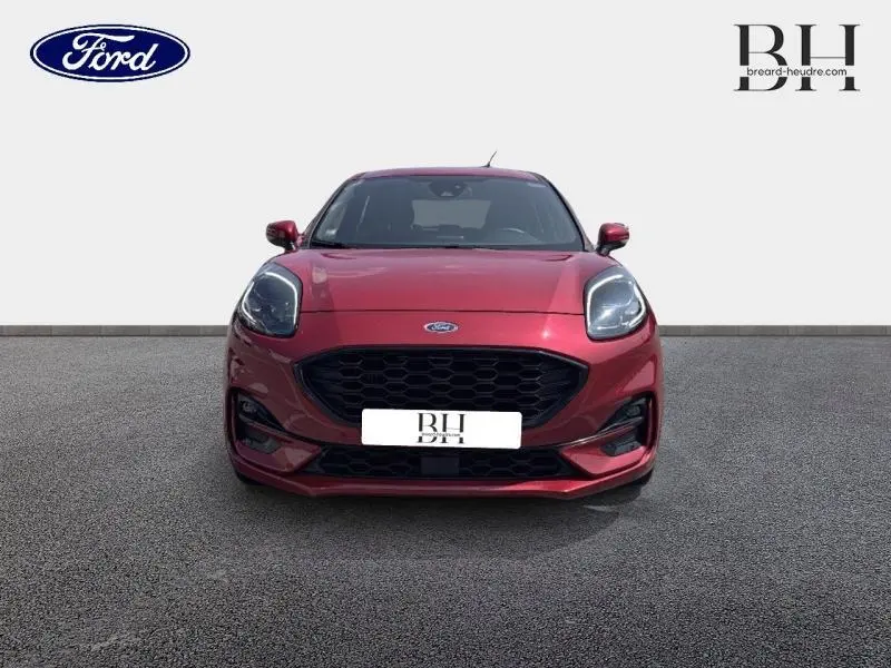 Vue de face d'une Ford Puma 1.0 EcoBoost rouge métallisée avec calandre noire et phares LED marqués.