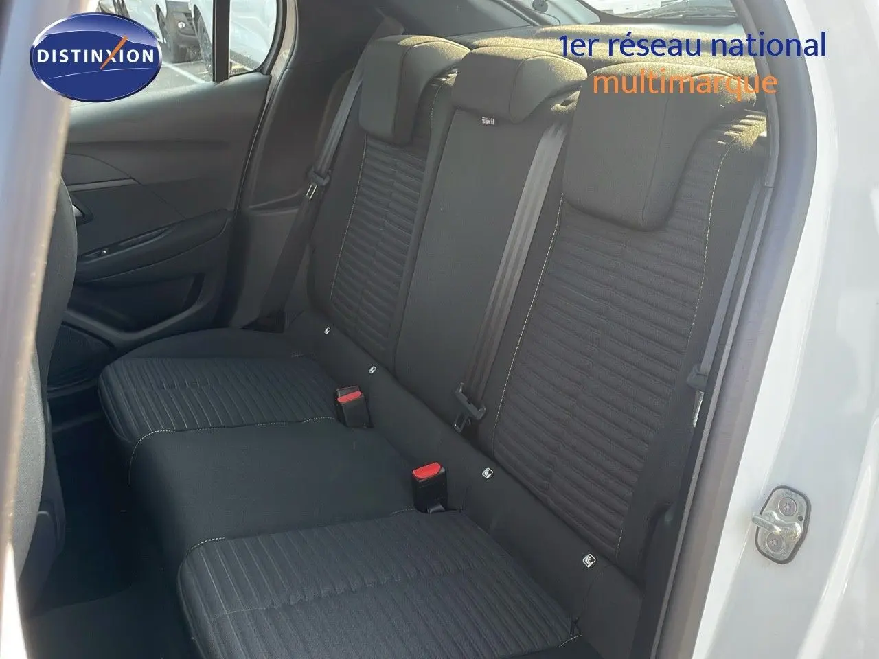 Vue intérieure côté arrière droit montrant les sièges arrière noirs sur Peugeot 208 blanc banquise 2024.