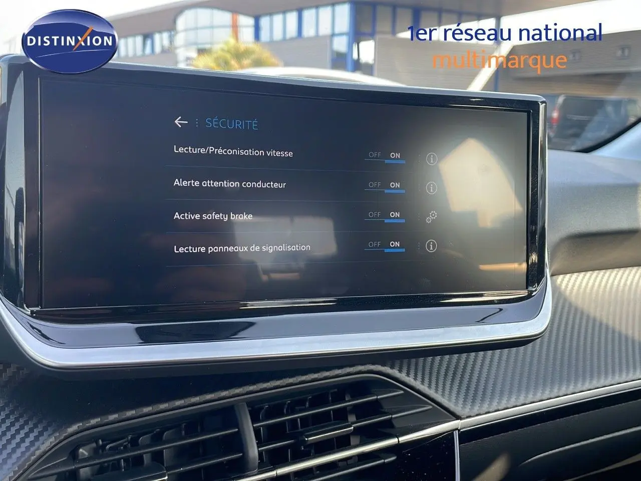 Écran tactile central affichant les options de sécurité dans l’habitacle d’une Peugeot 208 blanche, vue intérieure.