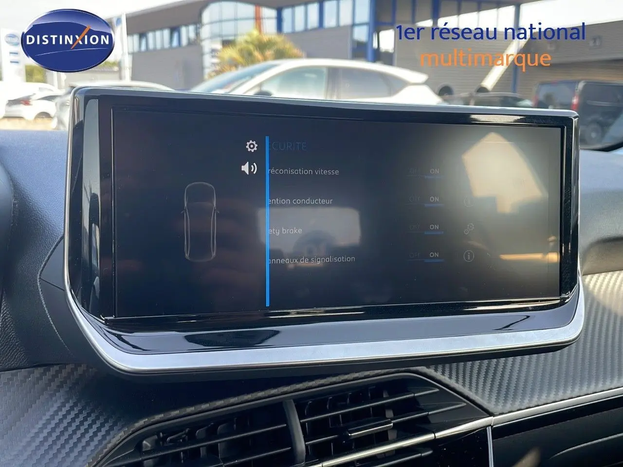 Écran tactile central du tableau de bord de la Peugeot 208 2024, avec interface de réglages de sécurité affichée.