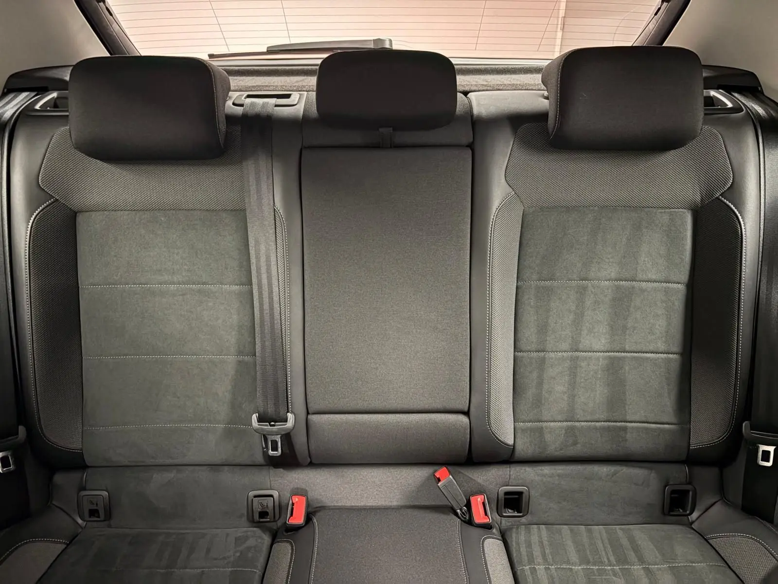 Vue intérieure des sièges arrière noirs du Volkswagen T-Roc 2025, avec appuie-têtes et ceintures visibles.