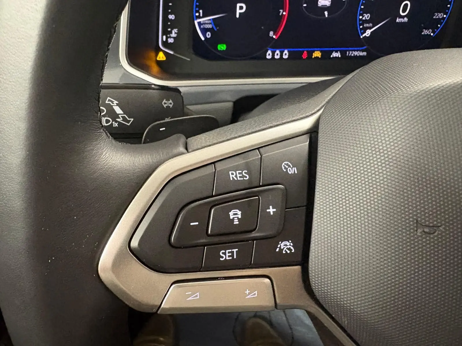 Gros plan sur le volant chauffant du Volkswagen T-Roc 2025, avec commandes intégrées et tableau de bord numérique visible.