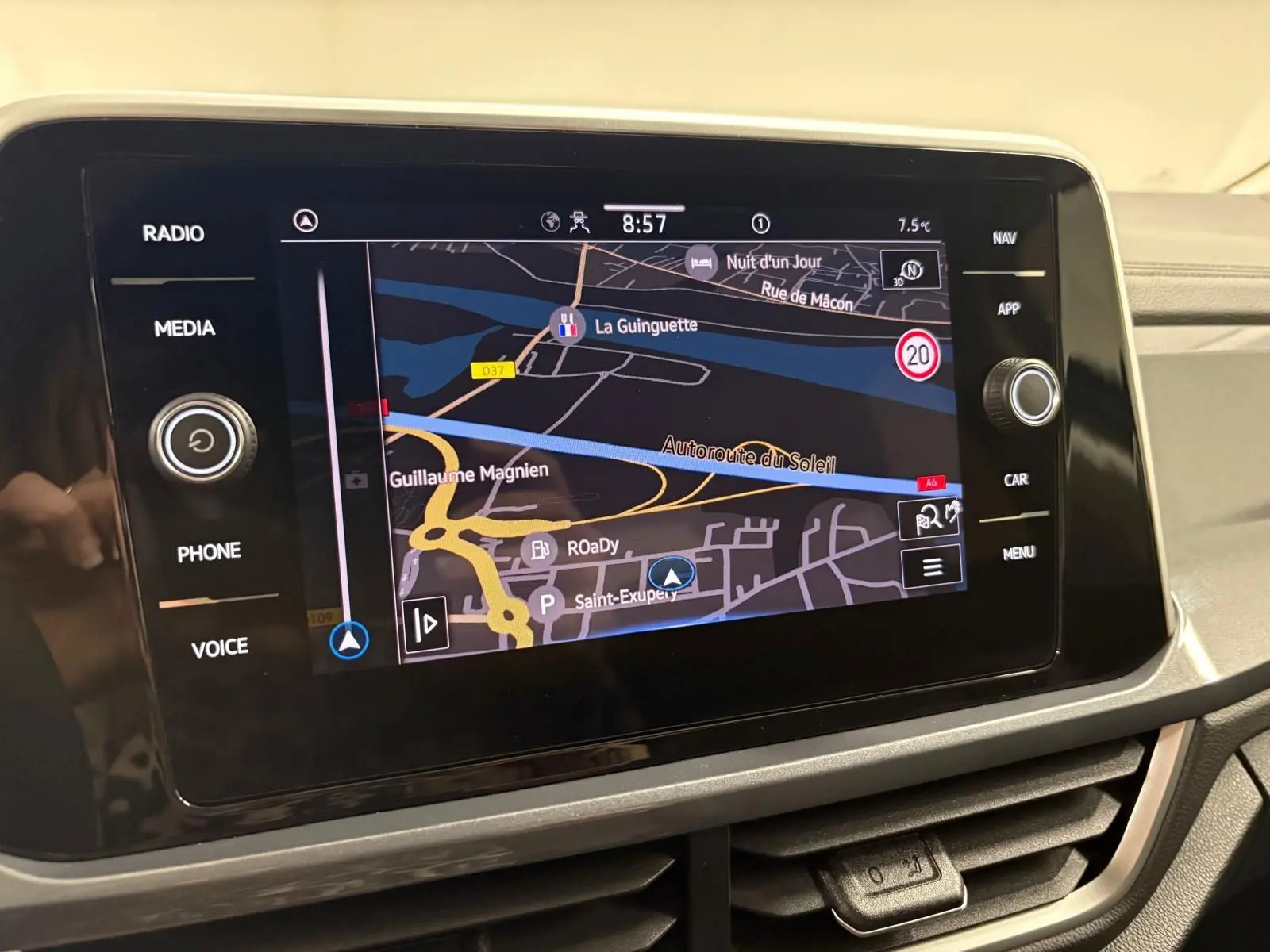 Écran tactile central du Volkswagen T-Roc bleu pétrole, affichant la navigation avec carte et commandes autour.