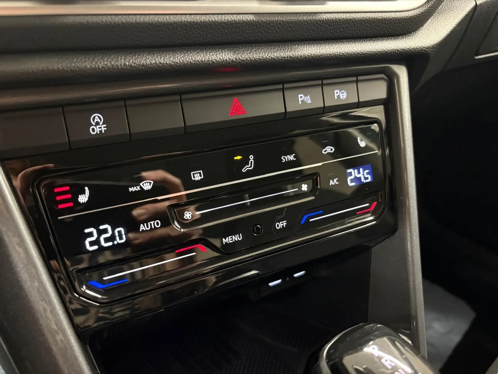 Gros plan sur la console centrale du Volkswagen T-Roc 2025, affichant la climatisation digitale et les commandes chauffantes.