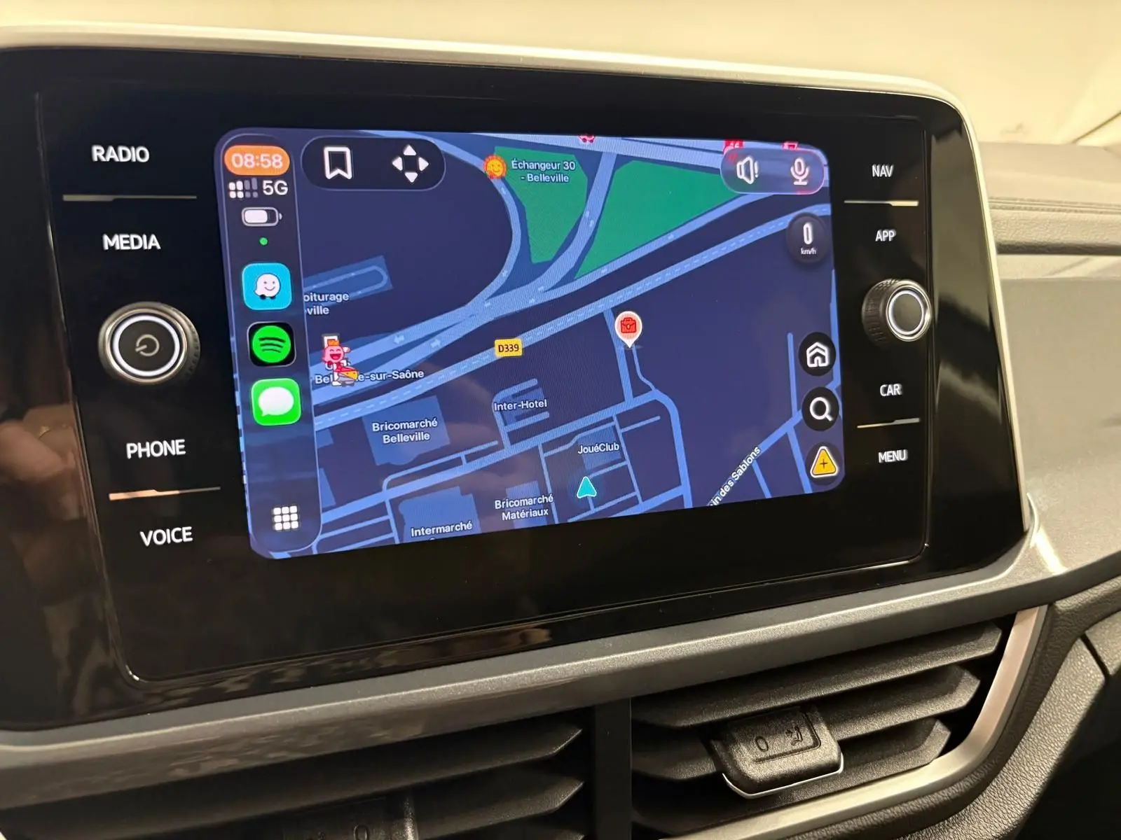 Écran tactile central du Volkswagen T-Roc 2025 affichant la navigation, vu de face dans l'habitacle.