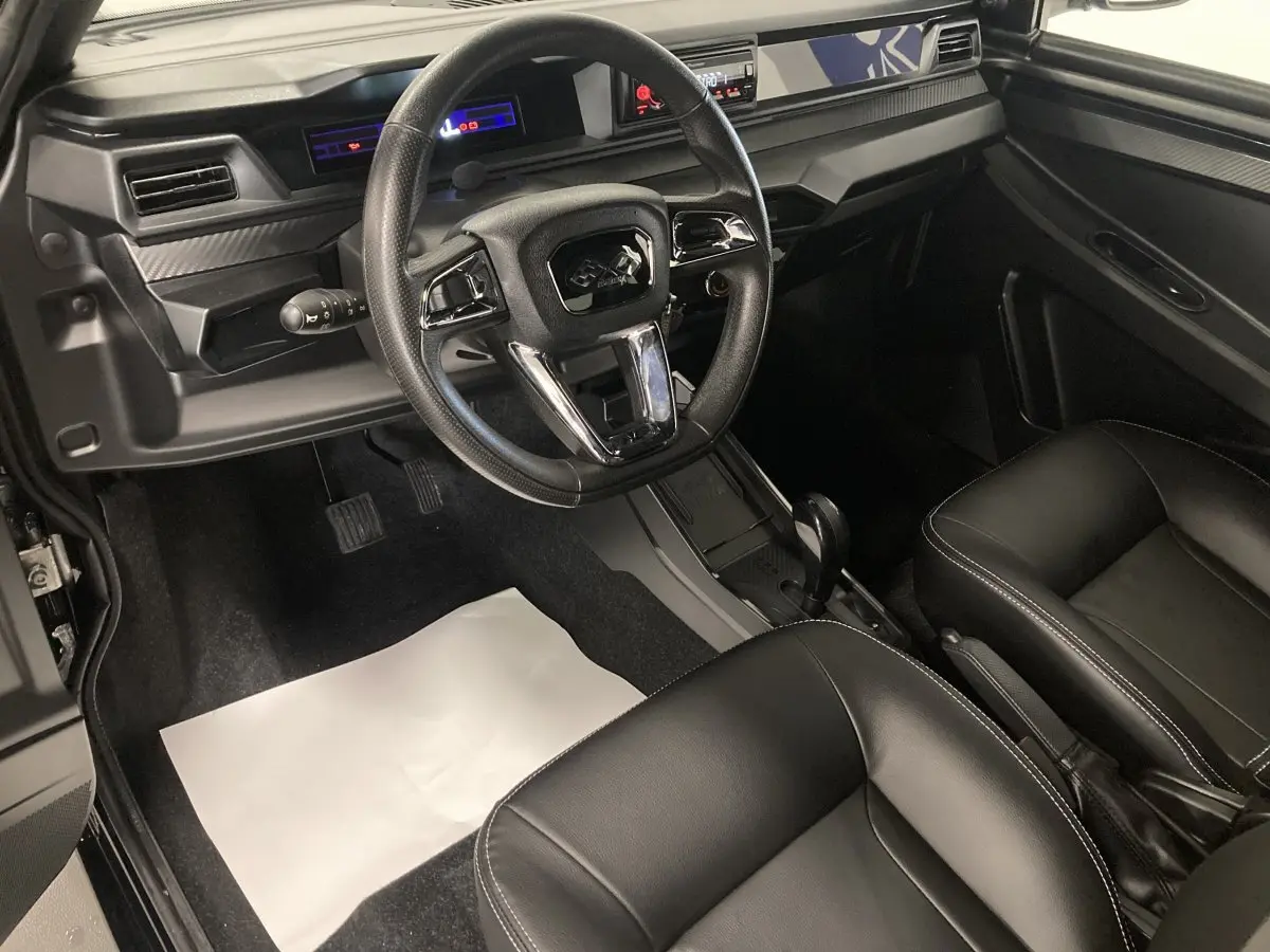 Intérieur noir de la Ligier JS50 0.5 REVO D+ SELECT 2026, vue côté conducteur sur tableau de bord et sièges confort.
