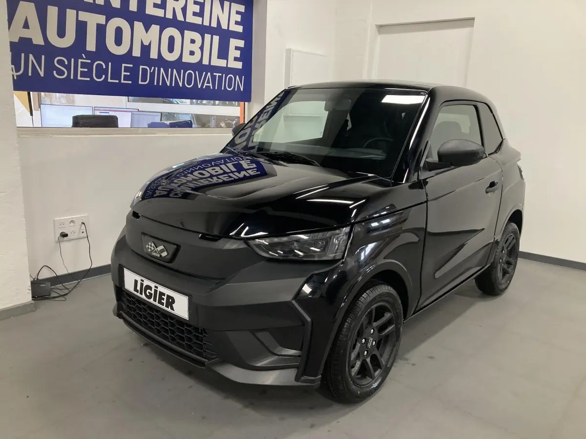 LIGIER JS50 0.5 REVO D+ noir vue 3/4 avant droit avec jantes alu noires et feux LED en intérieur showroom.