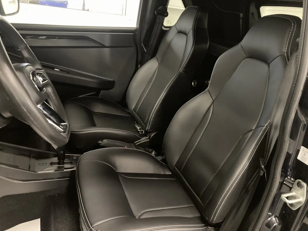 Vue intérieure côté gauche montrant les sièges confort noirs avec surpiqûres blanches du Ligier JS50 0.5 REVO D+ SELECT 2026.