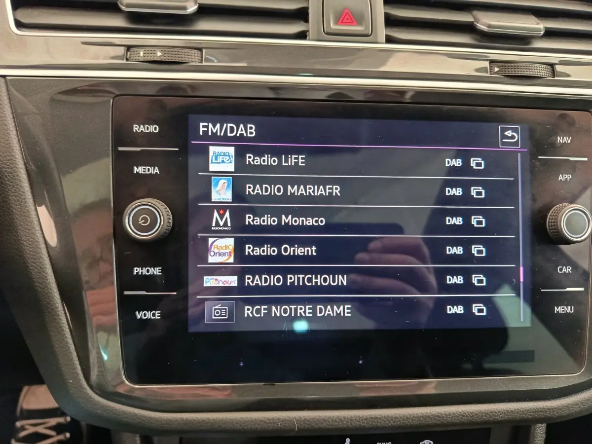Écran tactile central du Volkswagen Tiguan 2.0 TDI 150 DSG7 Elegance affichant les stations radio FM/DAB.