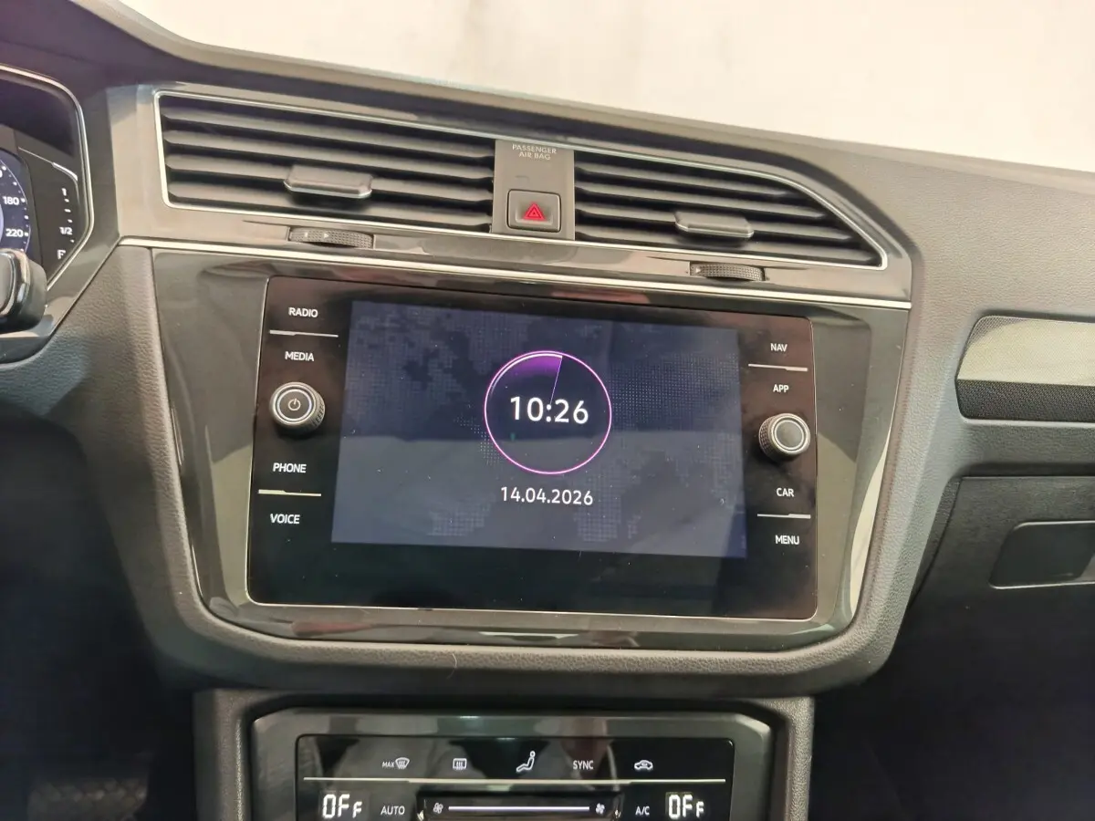 Vue intérieure centrée sur l’écran tactile et la console de climatisation du Volkswagen Tiguan 2022, finition élégante noire.