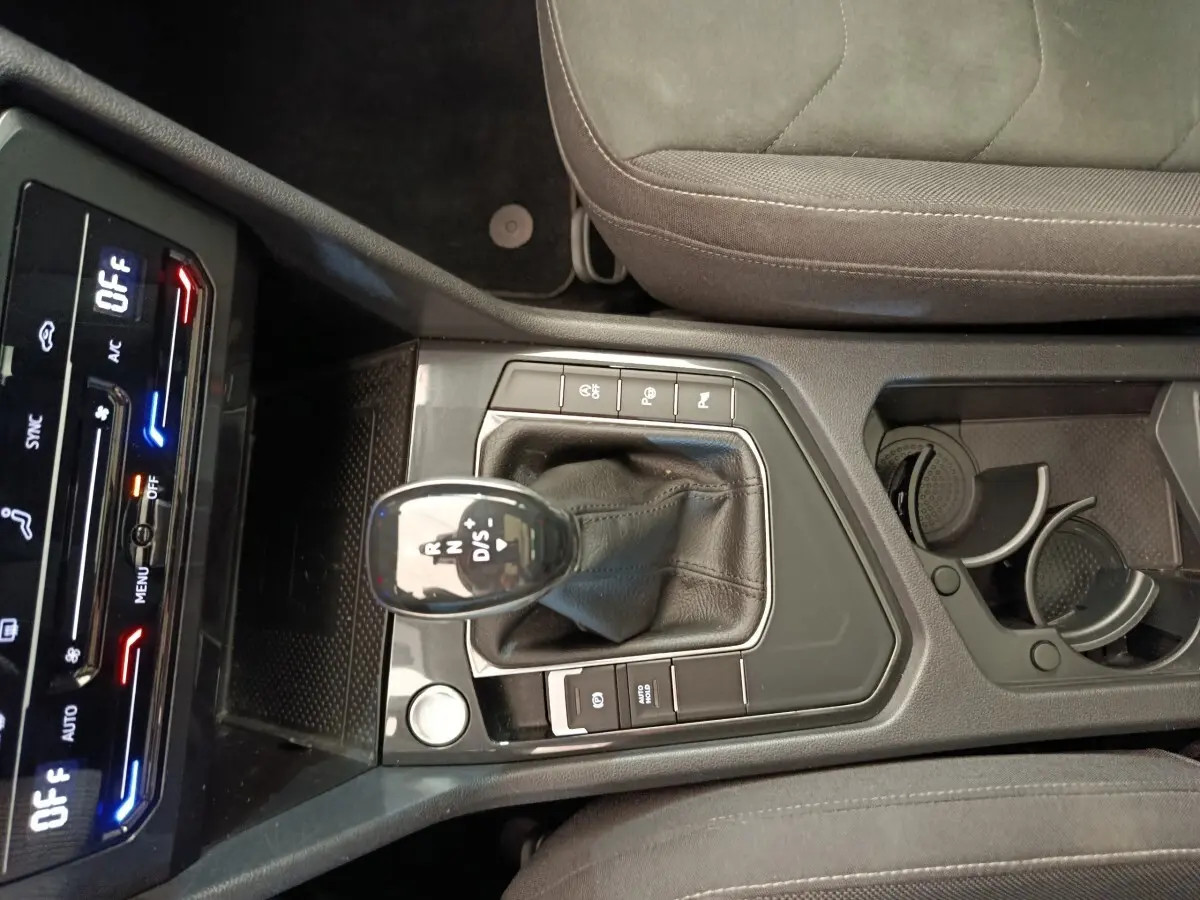 Vue plongeante sur la console centrale noire du Volkswagen Tiguan 2.0 TDI 150 DSG7 avec levier de vitesse et commandes tactiles.