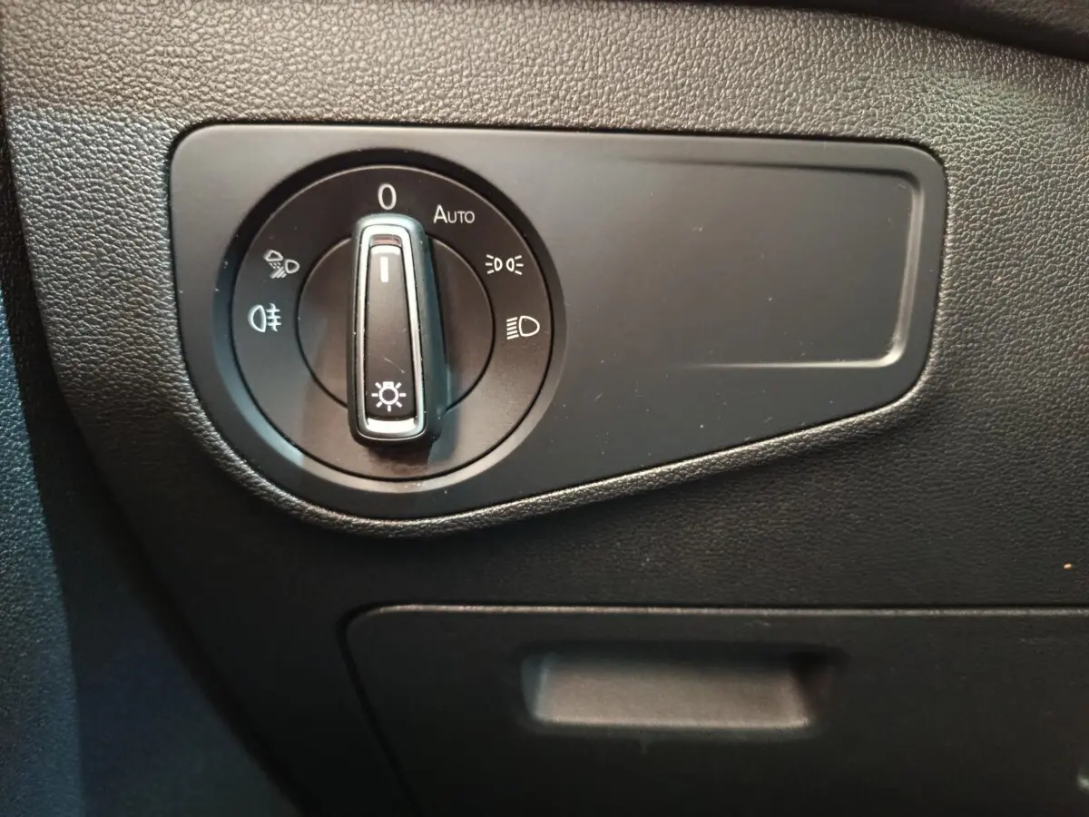 Gros plan sur le bouton de commande des phares dans l’habitacle du Volkswagen Tiguan noir, version 2022.