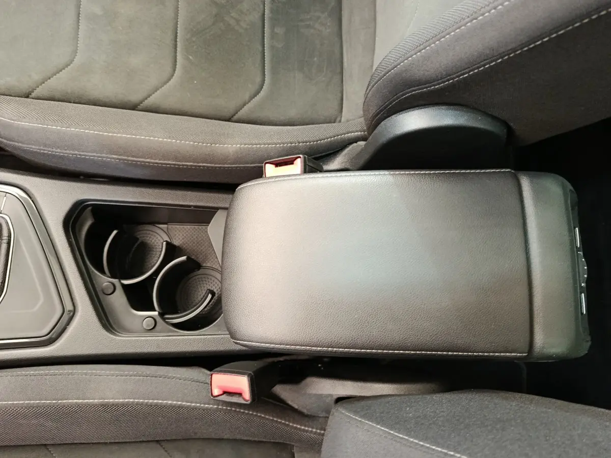 Vue rapprochée de l'accoudoir central noir et des porte-gobelets du Volkswagen Tiguan 2.0 TDI 150 DSG7 Elegance 2022.