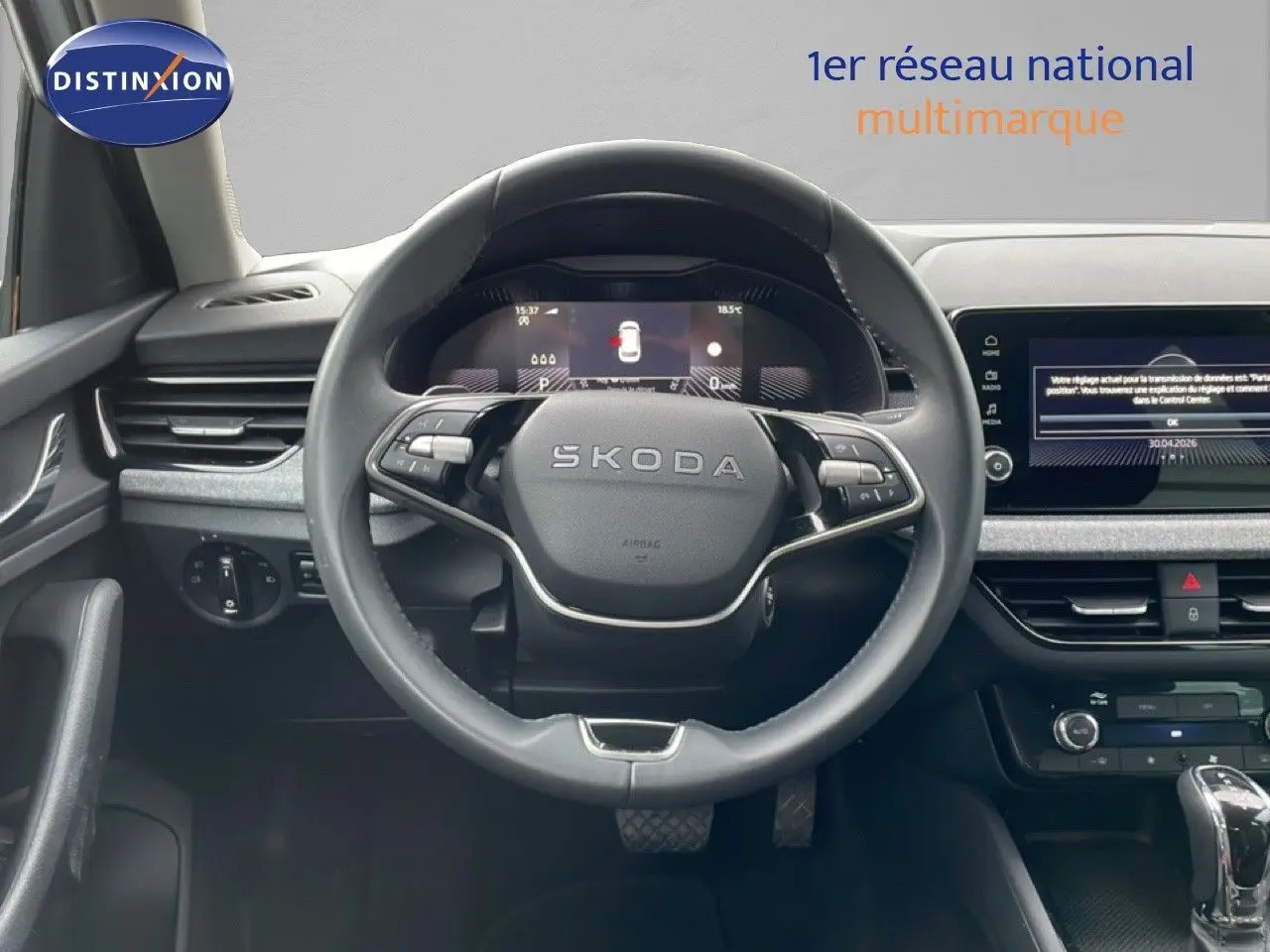 Vue intérieure centrée sur le volant noir du Skoda Kamiq 2025 avec tableau de bord digital et écran tactile.