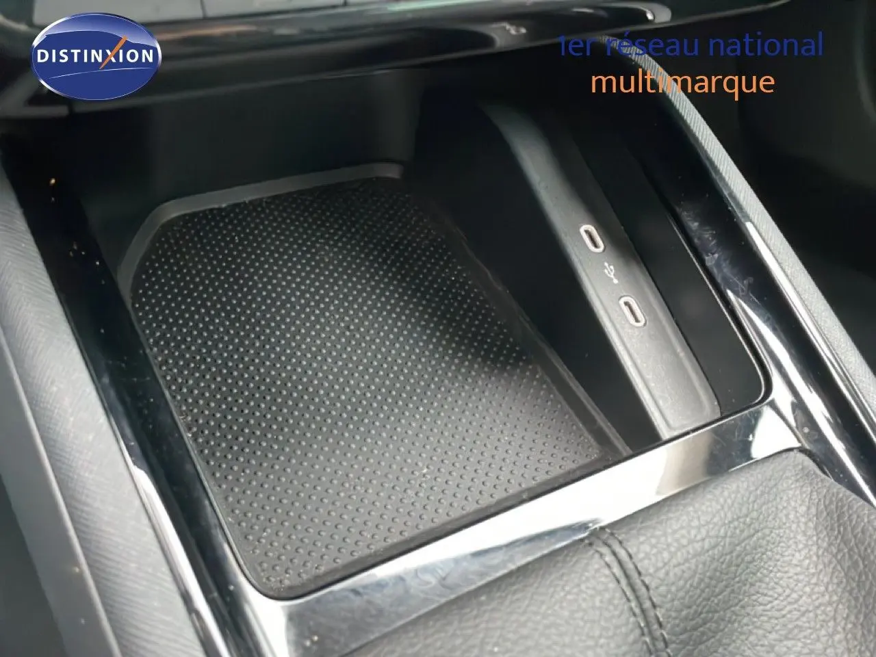 Gros plan sur la console centrale noire du Skoda Kamiq 2025, avec zone de recharge sans fil et ports USB visibles.
