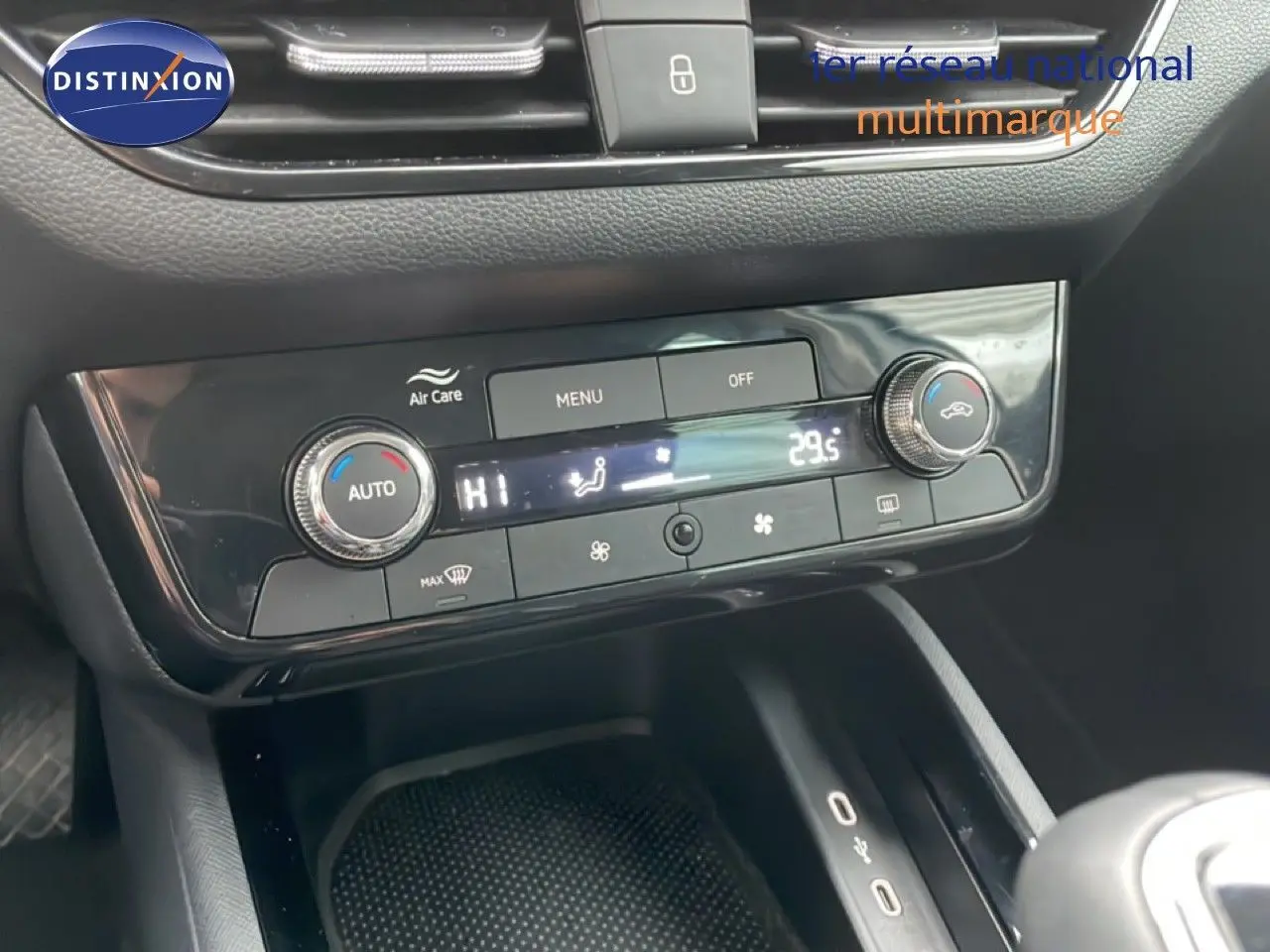 Vue rapprochée de la console centrale noire du Skoda Kamiq 2025, montrant les commandes de climatisation digitale.
