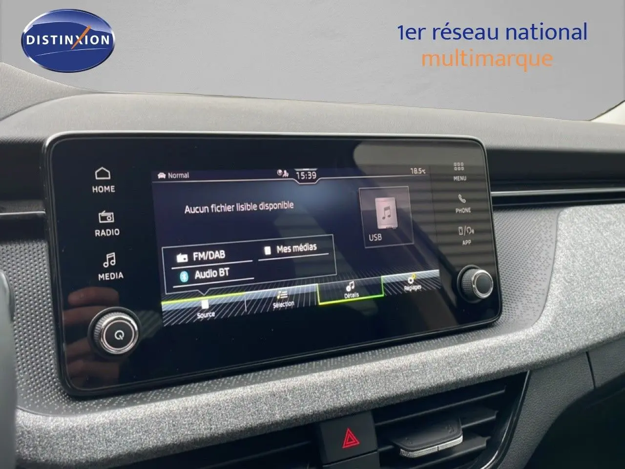 Vue intérieure centrée sur l’écran tactile multimédia du Skoda Kamiq blanc glacier, affichant les options audio USB et Bluetooth.