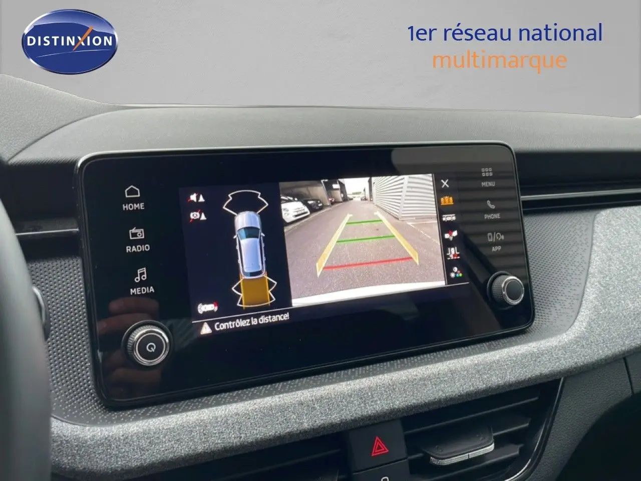 Écran tactile central du Skoda Kamiq blanc glacier 2025 montrant la caméra de recul avec guidage de trajectoire.