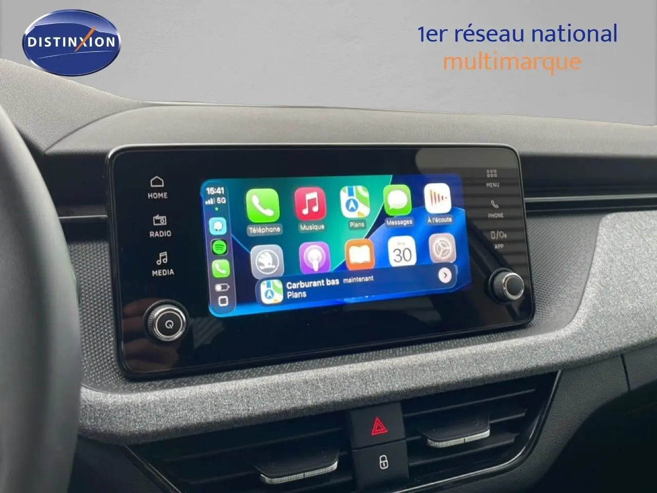 Vue intérieure du tableau de bord du Skoda Kamiq blanc glacier 2025, avec écran tactile multimédia allumé.