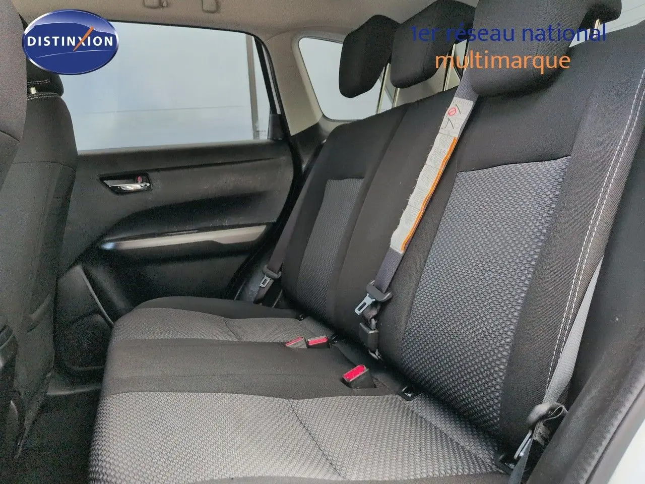 Vue latérale intérieure sur la banquette arrière en tissu noir avec surpiqûres blanches du Suzuki Vitara 2021.