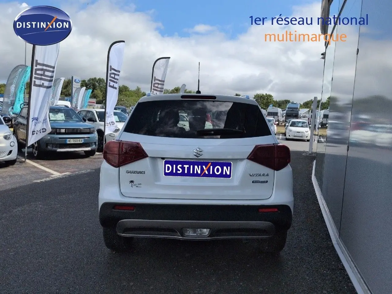 Vue arrière d'un Suzuki Vitara Galactic Gray métallisé, avec feux arrière LED et hayon fermé sur parking.