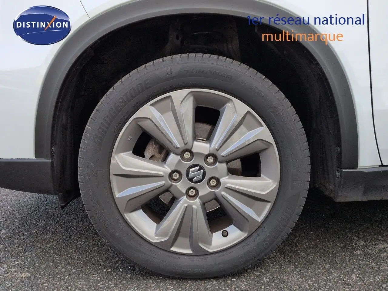 Gros plan sur la roue avant gauche du Suzuki Vitara 1.4 Boosterjet Hybrid 2021 en Galactic Gray métallisé.