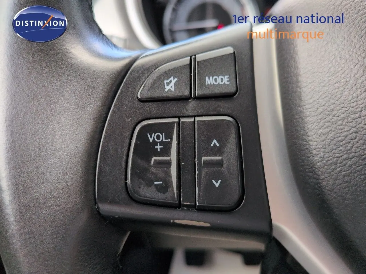 Gros plan sur les commandes audio au volant noir du Suzuki Vitara Galactic Gray 2021, montrant les boutons volume et mode.