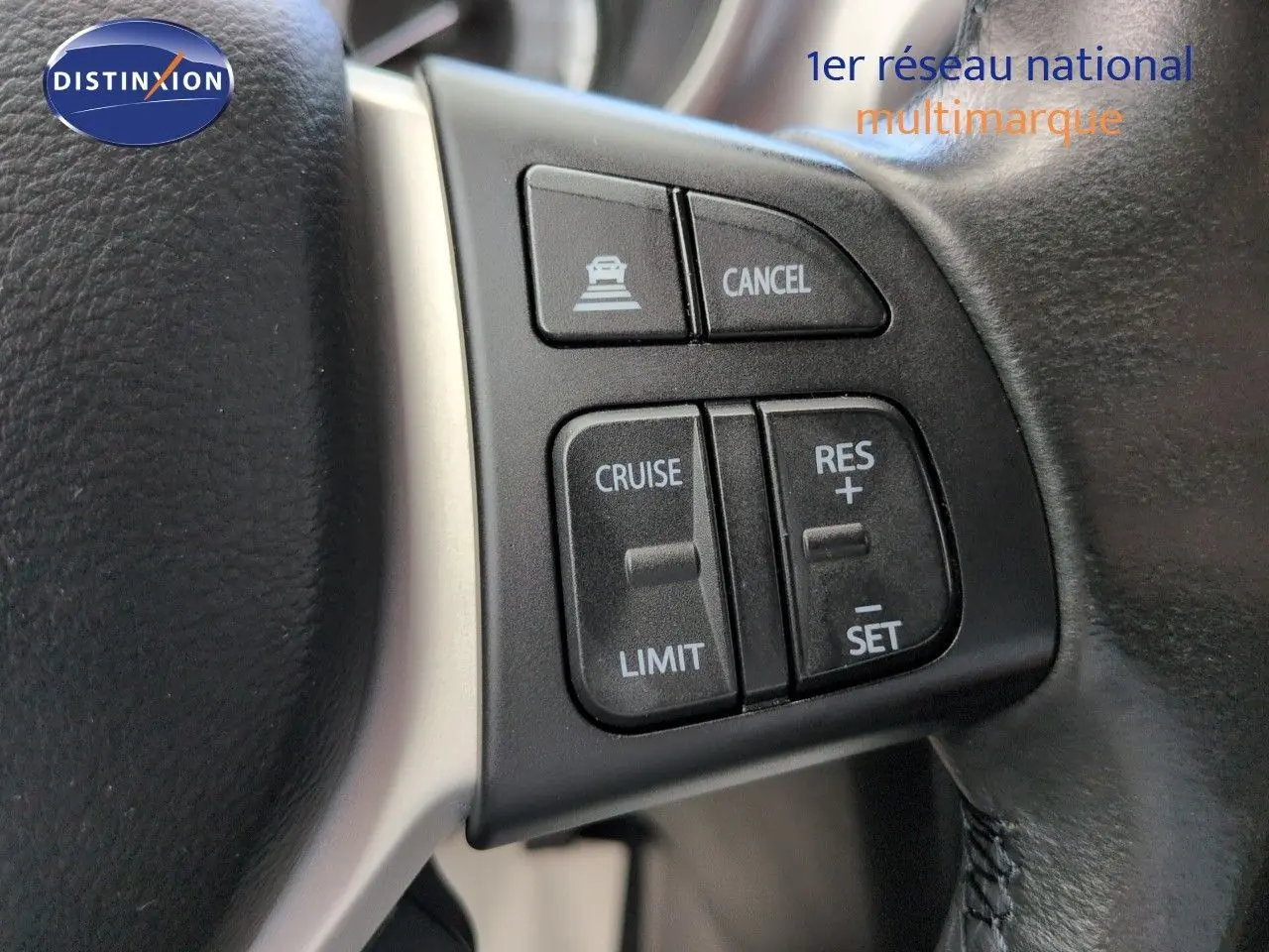 Gros plan sur les commandes de régulateur de vitesse au volant cuir noir du Suzuki Vitara Galactic Gray.