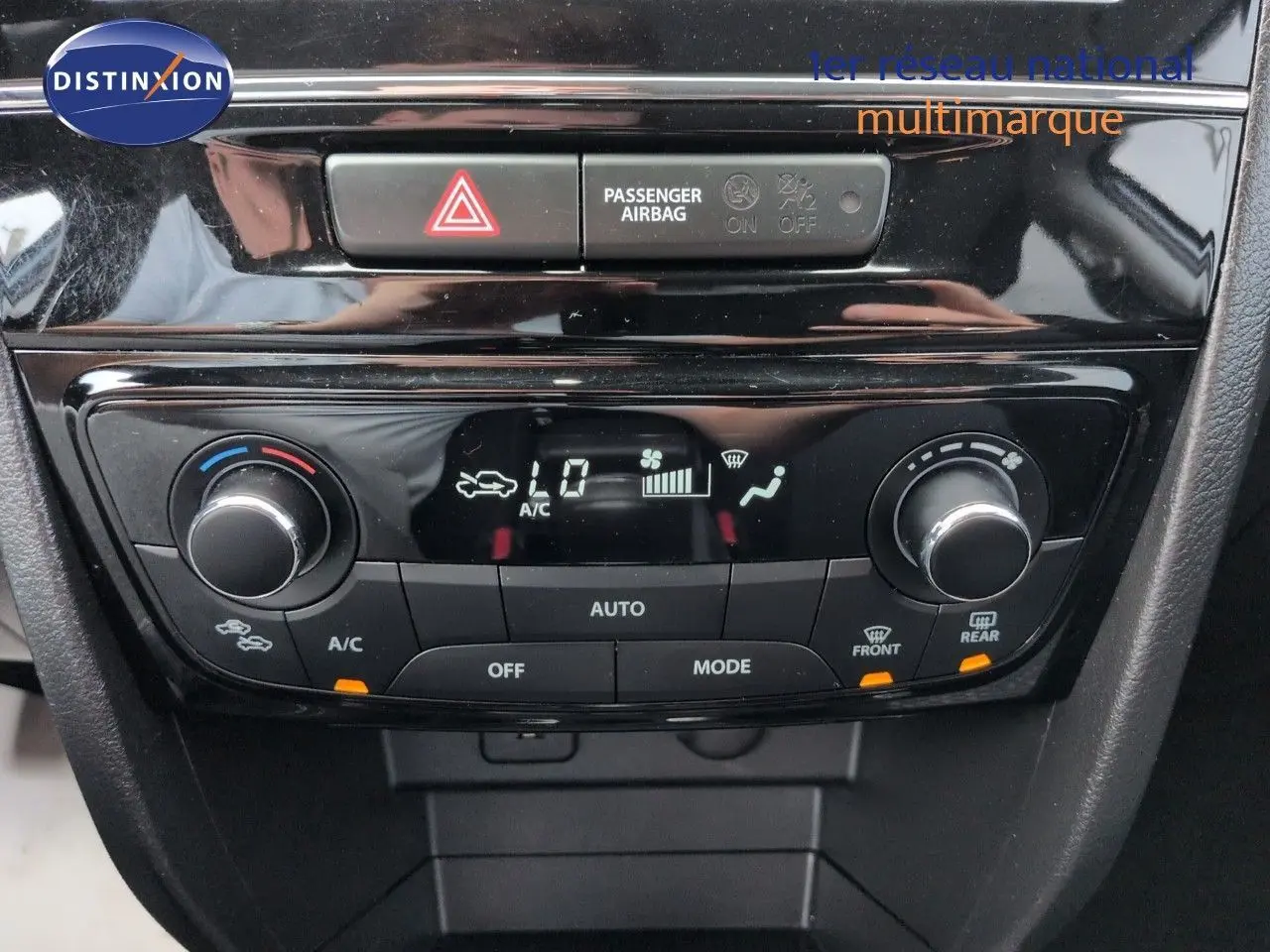 Vue rapprochée de la console centrale noire du Suzuki Vitara 1.4 Boosterjet Hybrid avec commandes de climatisation digitales.